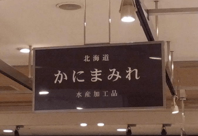 百貨店催事に掲げられた、かにまみれの看板
